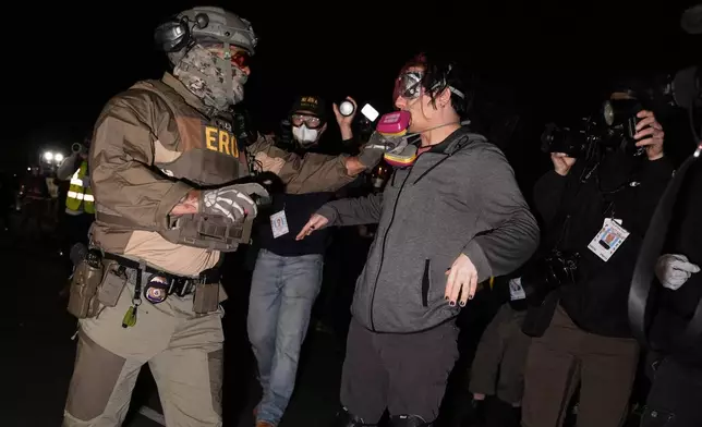 一名聯邦移民官員在迪萊尼大樓拘留中心外，拉扯一名示威者的防毒面罩。攝於2026年5月28日周四，新澤西州紐瓦克。(美聯社圖片/Angelina Katsanis) AP圖片