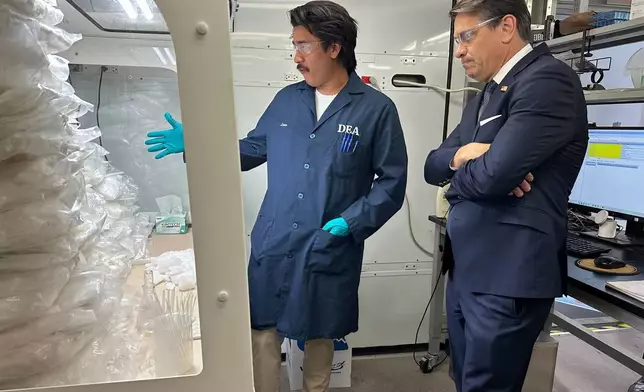 署理司法部長托德·布蘭奇（Todd Blanche）於2026年5月6日周三在鳳凰城，與緝毒局（DEA）流動實驗室的一名技術人員交談，該技術人員正在測試檢獲的毒品。(美聯社圖片/Rebecca Santana) AP圖片