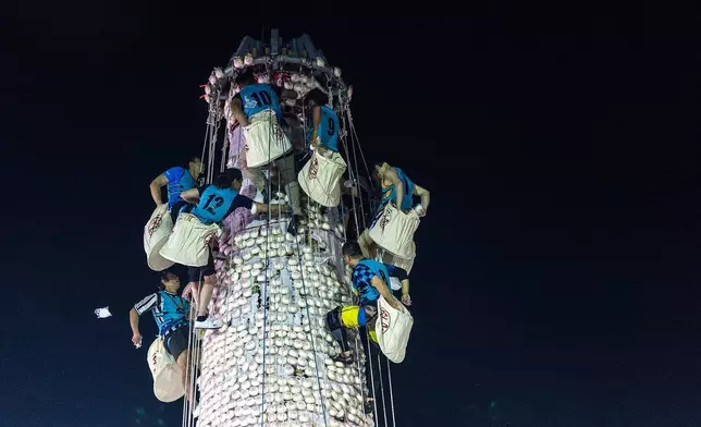 2026年5月25日周一，香港長洲島太平清醮期間，參賽者從鋪滿膠包的包山收集包子。(美聯社圖片/Chan Long Hei) AP圖片