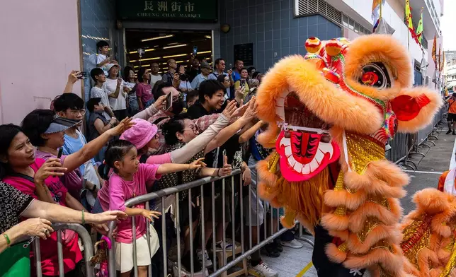 一名參賽者於2026年5月24日周日，在香港長洲太平清醮的飄色巡遊中表演舞獅。(美聯社圖片/Chan Long Hei) AP圖片