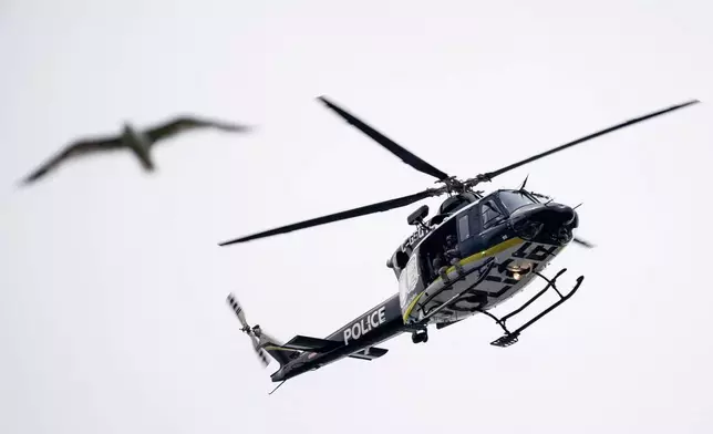 周一（2026年6月22日），一架蒙特利爾警用直升機在蒙特利爾槍擊案現場附近巡邏。(Christopher Katsarov/The Canadian Press via 美聯社圖片) AP圖片