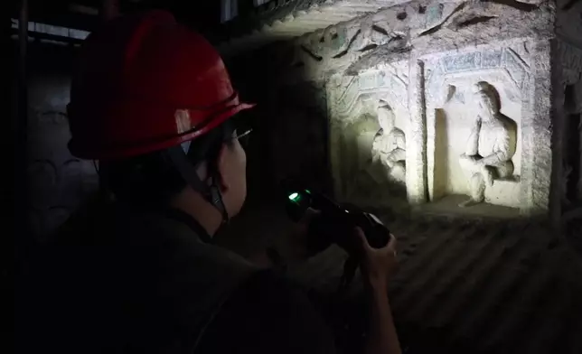 雲岡研究院數碼保存中心職員周宇超，十年來一直帶領團隊，為石窟進行數碼記錄。CCTV影片截圖
