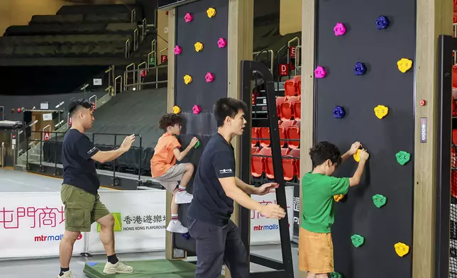 小朋友在攀石板上運用手腳協調向上攀登