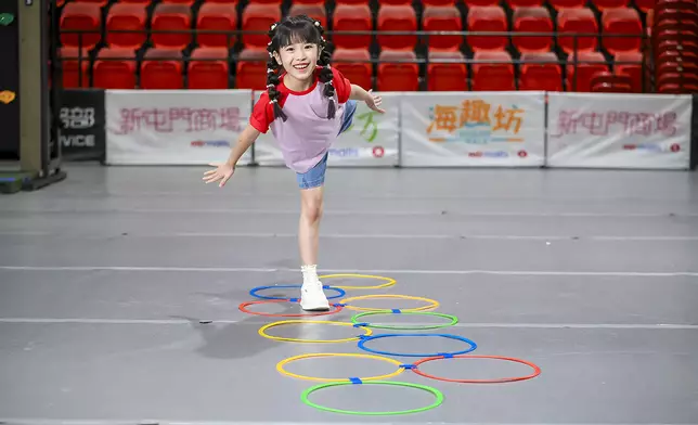 小朋友在室內感統區進行呼拉圈跳格訓練