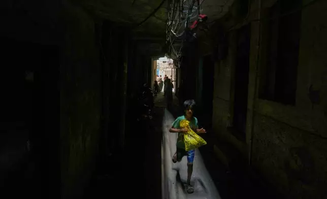 一名男童跑過印度新德里一幢今早發生火警的餐廳及酒店大廈旁邊的黑暗小巷。2026年6月3日周三。(美聯社圖片/Manish Swarup) AP圖片