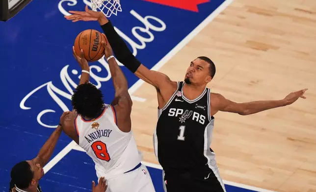 紐約時間2026年6月10日周三，NBA總決賽第四場比賽上半場，紐約人隊前鋒阿奴諾比（8號）在紐約嘗試在聖安東尼奧馬刺隊前鋒維克托·文班亞馬（1號）頭上投籃。(美聯社圖片/法蘭克·富蘭克林二世) AP圖片