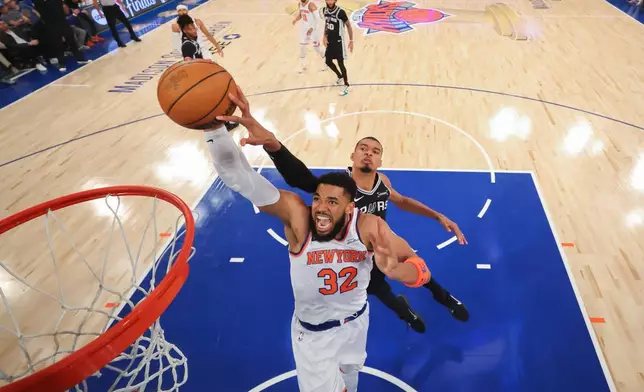 2026年6月8日周一，紐約，NBA總決賽第四場籃球賽上半場，紐約人隊中鋒卡爾-安東尼·唐斯（32號）在聖安東尼奧馬刺隊前鋒維克托·文班亞馬面前入樽。(美聯社圖片/Al Bello/Pool Photo) AP圖片