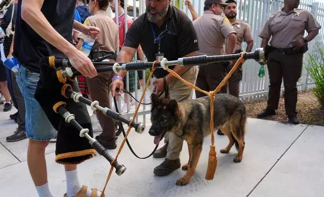 一隻保安犬檢查一名蘇格蘭足球迷的風笛，當時「格子軍團」正抵達觀看邁阿密馬林魚隊棒球賽。2026年6月22日周一。(美聯社圖片/Rebecca Blackwell) AP圖片
