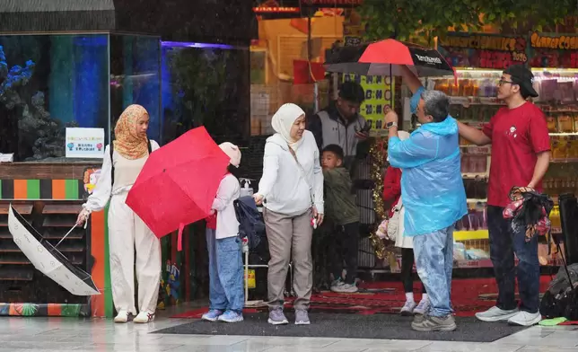 東京，周三（2026年6月3日），民眾在雨中收起雨傘進入商店。(美聯社圖片/Hiro Komae) AP圖片