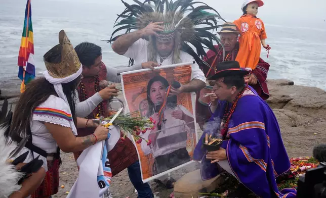 一名薩滿在秘魯利馬埃拉杜拉海灘舉行儀式，手持總統候選人藤森惠子的海報，為周一（二零二六年六月一日）舉行的總統決選祈福。(美聯社圖片/Martin Mejia) AP圖片