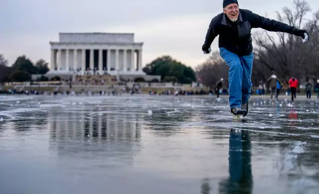 檔案圖片：華盛頓國家廣場結冰的倒影池上，來自馬里蘭州塔科馬公園的Dan DeMocker滑冰時，將冰塊推向家人，林肯紀念堂清晰可見，2022年12月26日。（美聯社圖片/Andrew Harnik，檔案圖片） AP圖片
