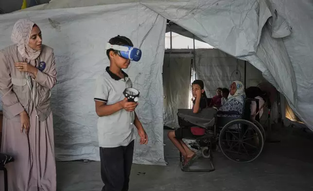 11歲的艾哈邁德·馬塔爾，周三（2026年6月17日）在加沙地帶中部扎瓦伊達一個由醫療科技團隊營運的帳篷內，利用虛擬實境（VR）頭戴式裝置參與心理支援環節。(美聯社圖片/Abdel Kareem Hana) AP圖片
