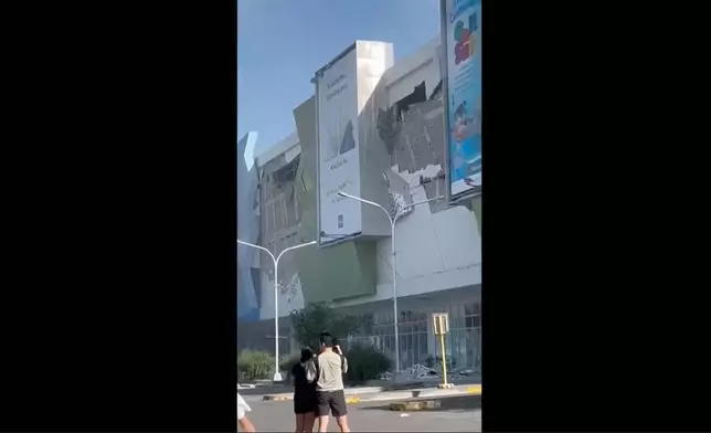 影片截圖顯示，菲律賓棉蘭老島桑托斯將軍市一幢受損建築物外，周一（2026年6月8日）在強烈地震後聚集的人群。 (美聯社圖片/Ernesto Torres Jr) AP圖片
