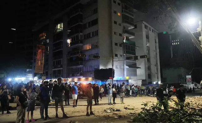 人們在委內瑞拉加拉加斯地震後，站在受損建築物外。周三，2026年6月24日。(美聯社圖片/Adrian Naranjo) AP圖片