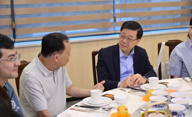 李家超（右）與長者互動交流。政府新聞處圖片