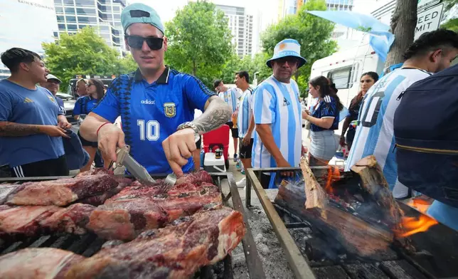 來自達拉斯的阿根廷球迷馬蒂亞斯·維德拉，在球隊於周日（2026年6月21日）對奧地利的世界盃J組足球賽事前，於一場集會上檢查燒烤爐上的肉類。(美聯社圖片/Julio Cortez) AP圖片