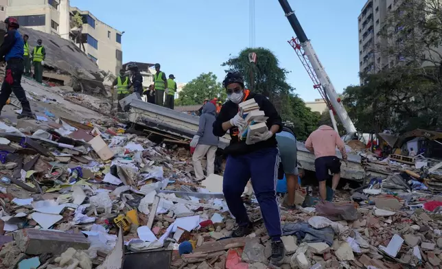 2026年6月25日周四，委內瑞拉加拉加斯，居民在地震中倒塌的建築瓦礫中搜救。(美聯社圖片/Ariana Cubillos) AP圖片