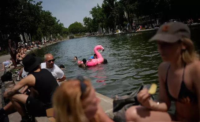 巴黎民眾在聖馬丁運河沐浴。法國國家氣象局將全國約一半、共54個省份置於紅色熱浪警報之下。攝於2026年6月23日周二。(美聯社圖片/Christophe Ena) AP圖片