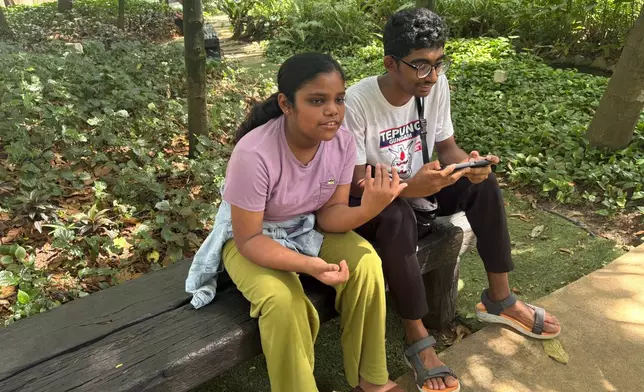 (美聯社圖片/Eileen Ng) 十二歲的Saaradha Saravanan（左）及十五歲的Aadhavan Saravanan，周一（二零二六年六月一日）在馬來西亞吉隆坡附近的八打靈再也一個公園內坐著。 AP圖片