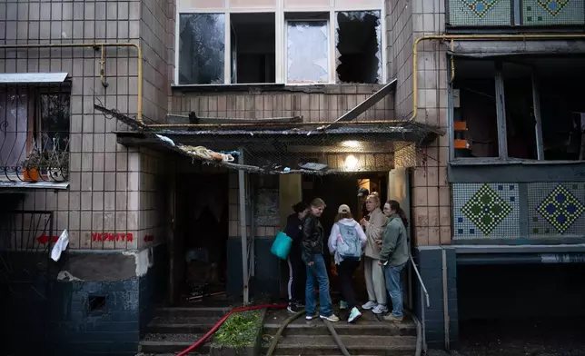 周一（2026年6月15日），烏克蘭基輔遭俄羅斯夜間襲擊後，當地居民聚集在受損住宅大廈入口附近。(美聯社圖片/Danylo Antoniuk) AP圖片