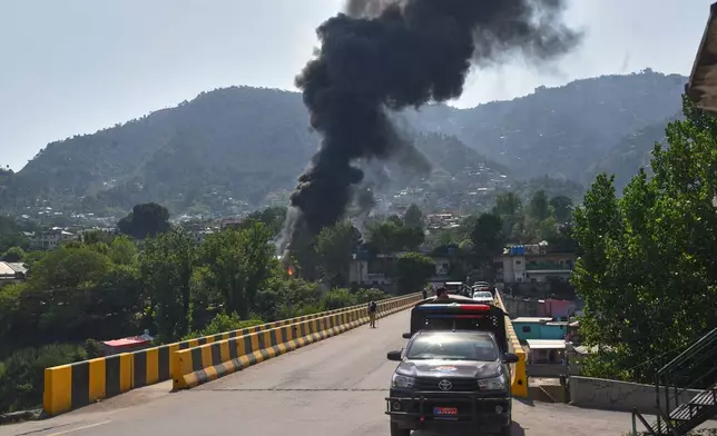 一架陸軍MI-17直升機因技術故障墜毀後，濃煙在巴基斯坦管轄的克什米爾首府穆扎法拉巴德升起，一輛警車停泊在路旁。攝於2026年6月10日周三。(美聯社圖片/M.D. Mughal) AP圖片