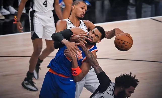 聖安東尼奧馬刺隊前鋒維克托文班亞馬，在聖安東尼奧舉行的NBA總決賽籃球系列賽第五場比賽上半場，從紐約人隊中鋒卡爾安東尼唐斯（中）手中將球拍走。攝於2026年6月13日，周六。(美聯社圖片/Darren Abate) AP圖片