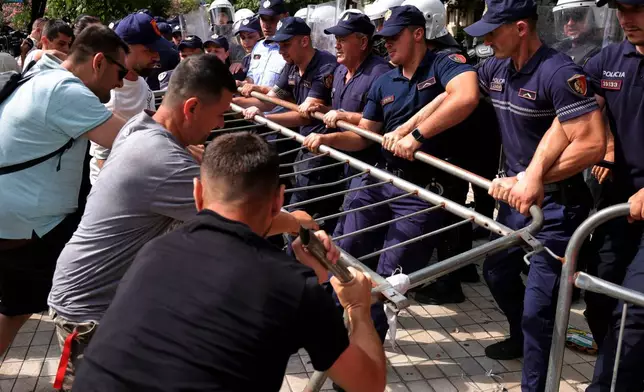 示威者在阿爾巴尼亞地拉那的反政府集會衝突期間試圖移開路障，警員則 удержи路障。攝於2026年7月2日周四。(美聯社圖片/Hameraldi Agolli) AP圖片