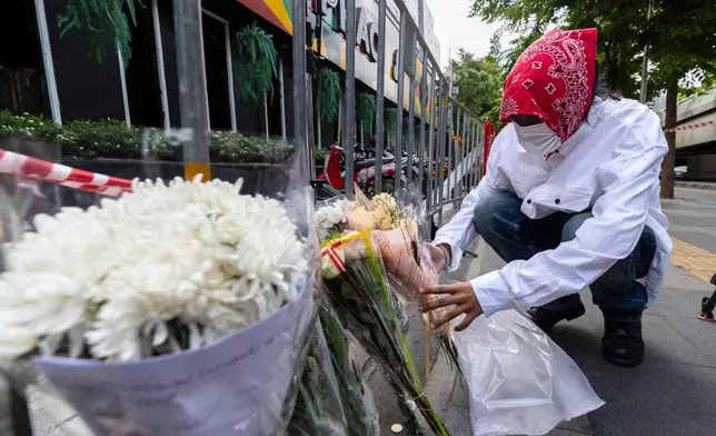 泰國曼谷，2026年7月14日周二，一名男子在涉事音樂酒吧外獻花，該酒吧發生火災造成多人死亡。（美聯社圖片/Wason Wanichakorn） AP圖片