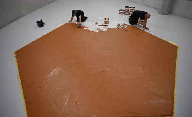 工作人員在地板上塗抹花生醬，重現「花生醬地板」藝術品，向荷蘭藝術家維姆·T·施佩爾斯致敬，攝於荷蘭鹿特丹博伊曼斯·范伯寧恩博物館，2026年7月3日周五。(美聯社圖片/穆內布·泰姆) AP圖片