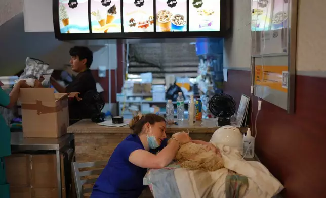 加布里埃拉·阿爾維斯在委內瑞拉拉瓜伊拉一間麥當勞餐廳撫摸她的愛犬。該餐廳被用作臨時醫療中心及寵物團聚中心。她於地震發生一周後尋回愛犬。攝於2026年7月2日周四。(美聯社圖片/Matias Delacroix) AP圖片