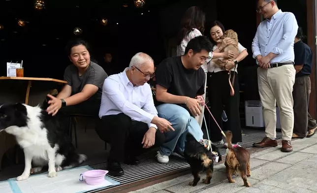 環境及生態局局長謝展寰（左二），以及立法會食物安全及環境衞生事務委員會主席陳凱欣（右二）和副主席楊永杰（右一）到訪西九文化區一所獲准食肆，並與攜狗顧客交流。政府新聞處圖片