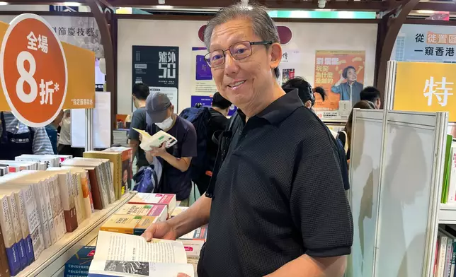 何先生在書展攤位翻閱書籍，享受隨手發現心水好書的樂趣。巴士的報記者攝