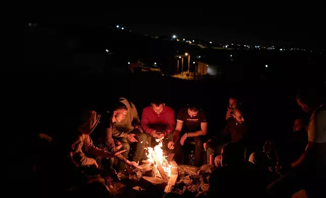 巴勒斯坦人坐在篝火旁，參與夜間巡邏，以防範以色列定居者襲擊約旦河西岸辛吉爾村莊。2026年7月16日周四。(美聯社圖片/Leo Correa) AP圖片