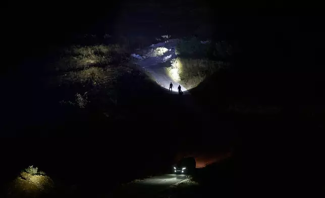 巴勒斯坦人發現山上有以色列定居者後使用電筒，他們參與夜間巡邏，以保護約旦河西岸辛吉爾村莊。2026年7月16日周四。(美聯社圖片/Leo Correa) AP圖片