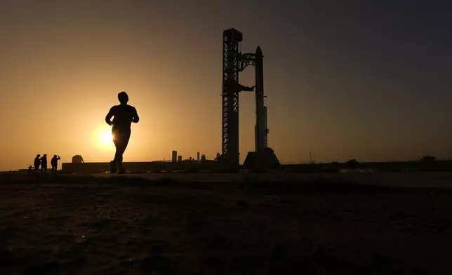 2026年7月24日周五，一名男子跑過SpaceX的巨型火箭「星艦」旁，該火箭正準備在德州星際基地進行測試飛行。(美聯社圖片/埃里克·蓋伊) AP圖片