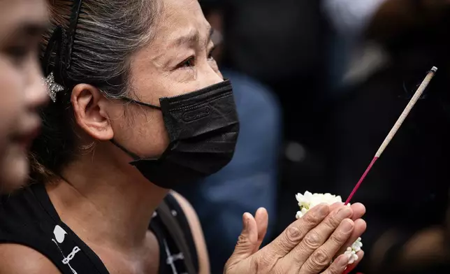 一名女子在泰國曼谷一間音樂酒吧外哭泣祈禱，該酒吧於周二發生火災，造成多人死亡。(美聯社圖片/Wason Wanichakorn) AP圖片