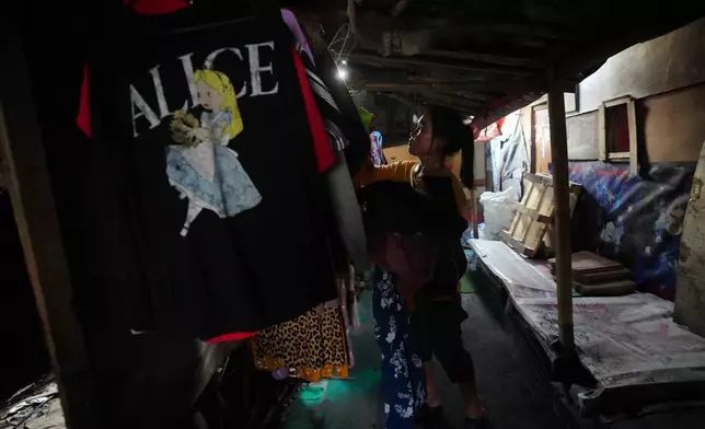 拾荒者努爾·溫西於印尼雅加達市郊班塔爾格邦堆填區附近的寄宿屋，收下晾乾的衣服。2026年7月6日周一。(美聯社圖片/Tatan Syuflana) AP圖片
