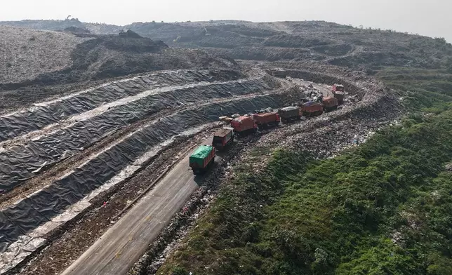 垃圾車於印尼雅加達市郊的班塔爾格邦堆填區，在卸下垃圾前排隊等候。2026年7月6日周一。(美聯社圖片/Tatan Syuflana) AP圖片