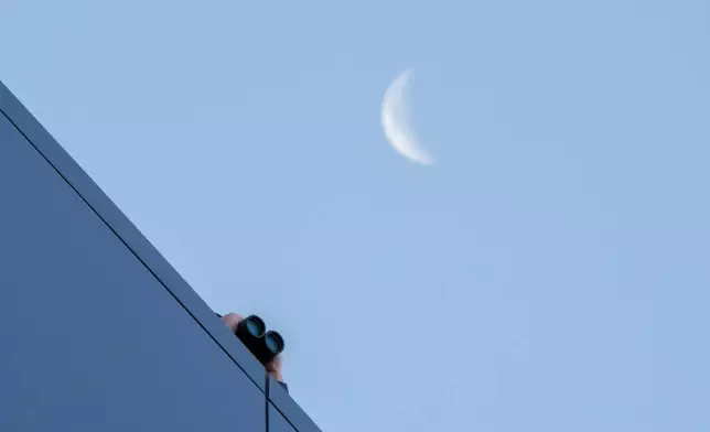 一名執法人員周四在猶他州普羅沃第四區法院屋頂上，用望遠鏡觀察。當日法院正為被控槍殺查理·科克的泰勒·羅賓遜舉行初審聆訊。(美聯社圖片/Spenser Heaps) AP圖片
