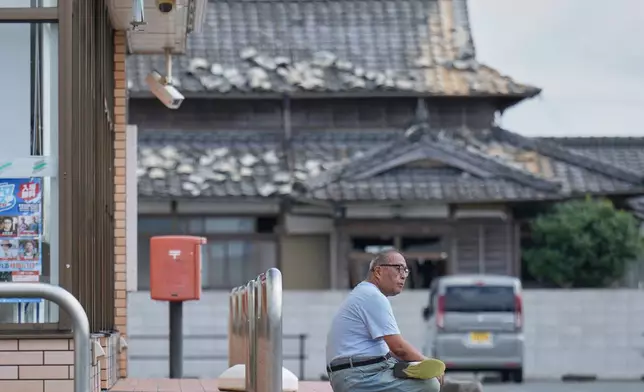 日本南部熊本縣宇城，一人坐在一間受地震損毀的房屋附近。攝於2026年7月30日周四。(美聯社圖片/Hiro Komae) AP圖片