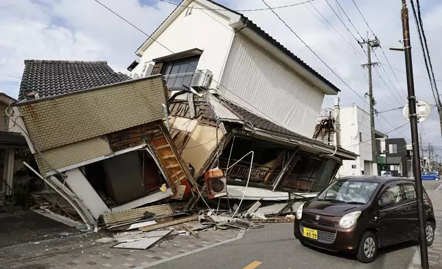 一輛汽車駛過地震後倒塌的房屋。攝於熊本縣八代市，周三，2026年7月29日。(共同社圖片/Juntaro Yokoyama 經美聯社轉發) AP圖片