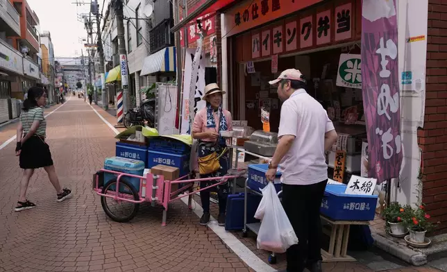 菅谷明子在東京的午市外賣店協助顧客購買豆腐，該店晚上會變為堂食餐廳。她於2026年7月4日周六開始推車販賣前，在店內工作。(美聯社圖片/Hiro Komae) AP圖片