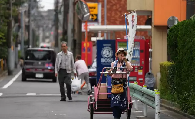 菅谷明子在東京推車販賣豆腐、預製食品及飲品時，吹奏舊式號角。攝於2026年7月4日周六。(美聯社圖片/Hiro Komae) AP圖片