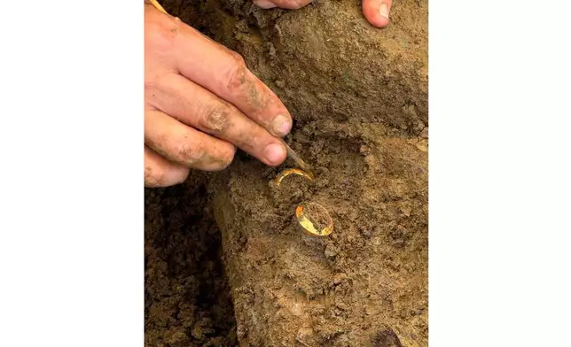泰國藝術廳發布的圖片顯示，一名考古學家在泰國佛丕府東艾通考古遺址的挖掘工作中，展示兩枚與人類骸骨一同出土的戒指，攝於2026年7月2日周四。(泰國藝術廳圖片/美聯社) AP圖片
