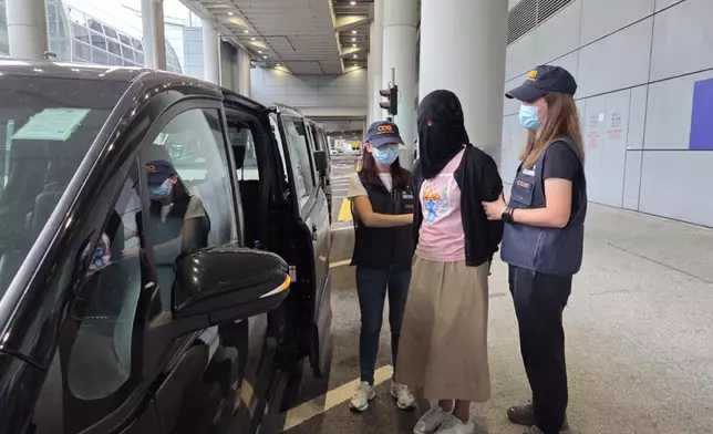 首宗案件其中一名被捕女子（中）被押上車。政府新聞處圖片