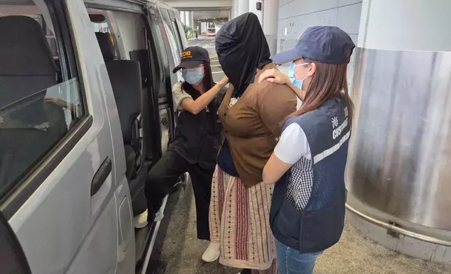 首宗案件其中一名被捕女子（中）被押上車。政府新聞處圖片