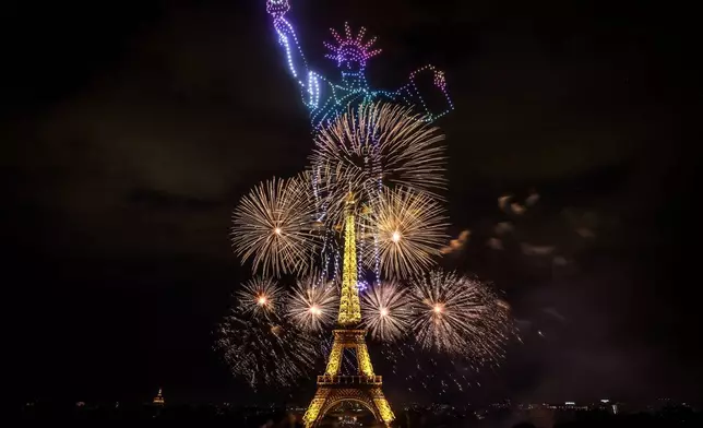 2026年7月13日周一晚，巴黎艾菲爾鐵塔在巴士底日慶祝活動前夕，被煙花和無人機照亮。(美聯社圖片/Thomas Padilla) AP圖片