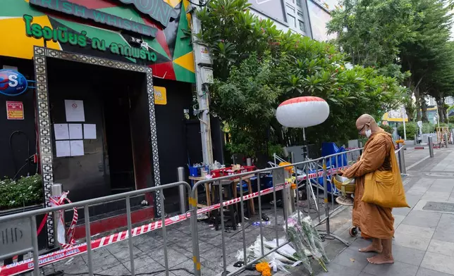 曼谷, 泰國, 周二, 2026年7月14日，一名佛教僧侶站在發生火警的音樂酒吧外，這次火警造成多人死亡。(美聯社圖片/Wason Wanichakorn) AP圖片