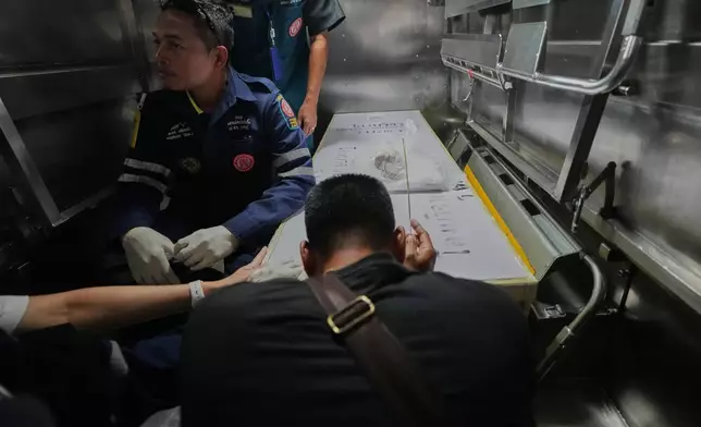 2026年7月14日周二，泰國曼谷一間警署醫院，一名音樂酒吧火災死者家屬向死者遺體致敬。(美聯社圖片/Sakchai Lalit) AP圖片