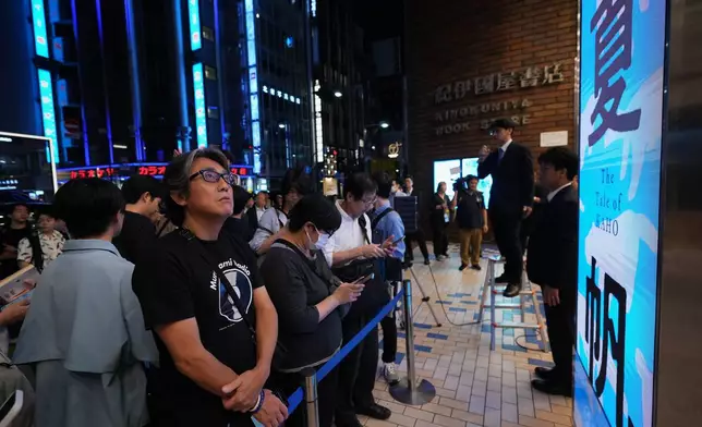 人們在東京紀伊國屋書店，於午夜十二時過後，參與村上春樹新書《加穗的故事》的倒數活動，領取預購的新書。攝於二零二六年七月二日周四。(美聯社圖片/Hiro Komae) AP圖片